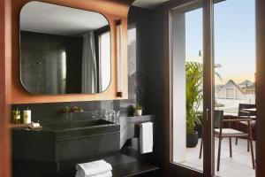 une salle de bain avec un lavabo et un miroir dans l'établissement Thompson Madrid, by Hyatt, à Madrid