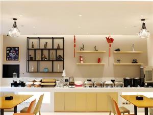 a kitchen with a counter with chairs and tables at City Comfort Inn Nanning Zoo Keyuan Avenue in Nanning