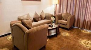 a living room with two couches and a coffee table at Hotel Ramada Plaza Hangzhou Xiaoshan in Chang-shen-tien