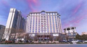 un gran edificio blanco en una ciudad con edificios en Mingfa International Hotel, en Yangzhou