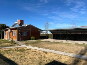 a brick building with a garage in a yard at cabañas elita in San Rafael