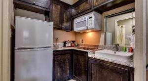 a kitchen with a white refrigerator and a sink at Americas Best Value Inn and Suites IAH Airport North in Houston +62 photos