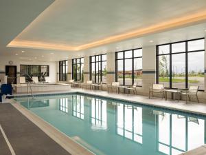 a swimming pool with chairs and tables in a building at Hyatt Place Billings in Billings