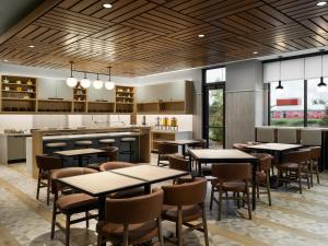 a restaurant with tables and chairs and a kitchen at Hyatt Place Billings in Billings