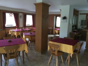 a restaurant with purple and yellow tables and chairs at Albergo Al Cocul in Sùtrio