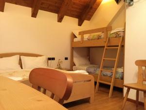 a room with two bunk beds and a table at Albergo Al Cocul in Sùtrio