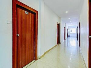 a hallway with a wooden door in a building at Hotel O Meridian Grand in Shamshabad