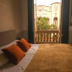 a bed with two pillows on it with a window at Happy House Hostel in Santiago +38 photos