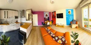 サン・ドニにあるuta house la plaineのリビングルーム(オレンジ色のソファ付)、キッチンが備わります。