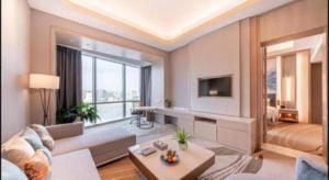 a living room with a couch and a large window at Howard Johnson by Wyndham Caexpo Plaza Nanning in Nanning