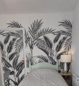 a bedroom with a bed with a mural of leaves at Cheltenham town centre with parking space in Cheltenham