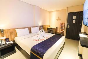 a hotel room with a bed with a towel on it at Fitra Hotel Majalengka in Majalengka +118 photos