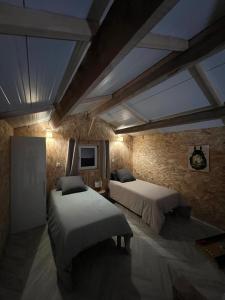 une chambre avec deux lits dans une pièce dans l'établissement Gîte du Moulin, à Commer