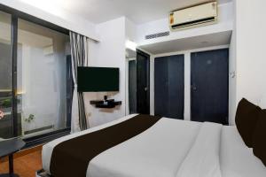 a bedroom with a large bed and a tv at Townhouse Oak Ballygunge Formerly Hotel Lovelock in Ballygunge +36 photos