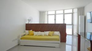 a bedroom with a bed with yellow sheets and a window at Apartamento en la playa de Piriápolis in Piriápolis +33 photos