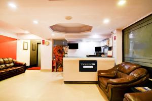 a living room with two leather chairs and a counter at Townhouse Oak Ballygunge Formerly Hotel Lovelock in Ballygunge