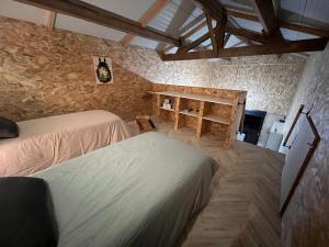 une chambre avec deux lits et une table dans l'établissement Gîte du Moulin, à Commer