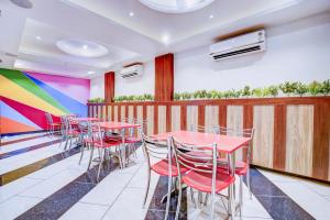 a row of tables and chairs with a colorful wall at Super Townhouse Zero Mile Gandhi Setu Formerly Classic Court in Gulzārbāgh