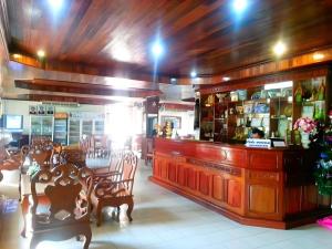 a restaurant with a bar and tables and chairs at Sisavath Hotel in Ban Houadông