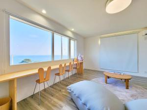 a room with a large window and chairs and a board at 「淡路島一棟貸宿　野うさぎ 」高台から海を望む貸別荘！2023年新築離れの素泊まり in Noda