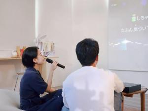 a man and woman singing into a microphone at 「淡路島一棟貸宿　野うさぎ 」高台から海を望む貸別荘！2023年新築離れの素泊まり in Noda