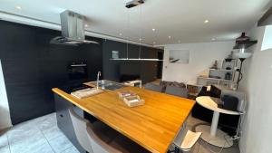 a kitchen with a wooden counter top in a room at Appartement 5 personne avec accès piscine jacuzzi disponibilité saisonnière in Villers-la-Ville