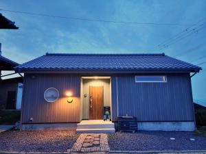 a small house with a door in front of it at 「淡路島一棟貸宿　野うさぎ 」高台から海を望む貸別荘！2023年新築離れの素泊まり in Noda