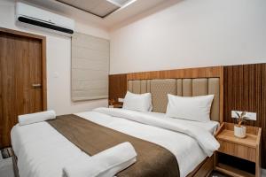 een slaapkamer met een groot bed met witte lakens bij Hotel SK Elite in Jodhpur +7 foto's