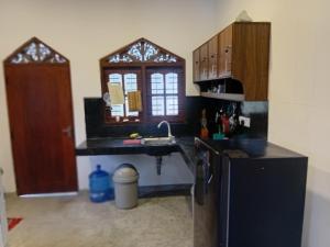 a kitchen with a sink and a refrigerator at Villa Blancas in Matara