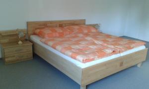 a bedroom with a wooden bed and a night stand at Ferienwohnung Brigitte in Bad Mitterndorf