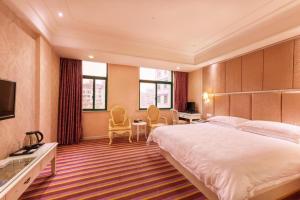 a hotel room with a large bed and a desk at mingjia hotel in Yiwu