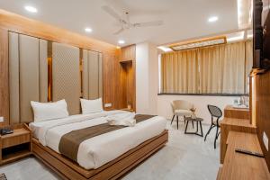 een slaapkamer met een bed, een bureau en een stoel bij Hotel SK Elite in Jodhpur