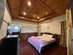 ein Schlafzimmer mit einem Bett und einer Holzdecke in der Unterkunft ลันตาไวท์ร็อค รีสอร์ท in Ban Nong Chaeng