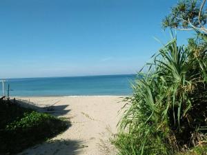 ein Sandstrand mit dem Meer im Hintergrund in der Unterkunft ลันตาไวท์ร็อค รีสอร์ท in Ban Nong Chaeng
