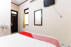 PampangにあるHotel O Wisma Pelita Masの赤いネットがかかったベッドのある部屋
