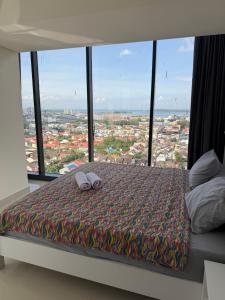 a bedroom with a bed with a view of a city at Luxury 2BR Sea View by Superstay in Batam Center
