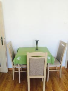 una mesa verde con sillas y un jarrón. en Śpiew Mew, en Ustka