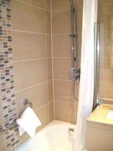 a bathroom with a shower with a sink and a tub at Mercure London Bloomsbury Hotel in London