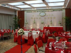 a banquet hall with red tables and chairs and a clock at Ramada Plaza by Wyndham Hangzhou Riverside in Hangzhou +72 photos