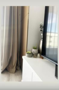 a living room with a television on a white dresser at H pipera in Voluntari +5 photos