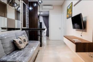 a living room with a couch and a television at Apartemen 2 Kamar Podomoro in Medan