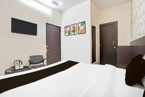 a hotel room with a bed and a chair at Collection O Prabhat Nagar Bareilly in Bareilly