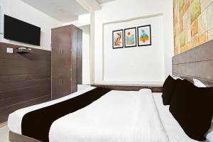 a bedroom with a large bed and a television at Collection O Prabhat Nagar Bareilly in Bareilly +39 photos