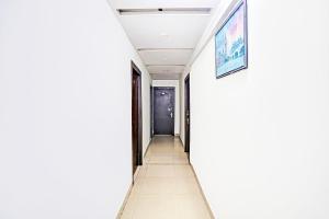a hallway with white walls and a white floor at Collection O Prabhat Nagar Bareilly in Bareilly