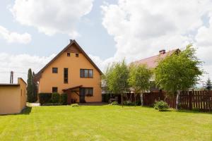 ein gelbes Haus mit einem Zaun und einem Hof in der Unterkunft Rekreačný Dom Mengusovce in Mengusovce