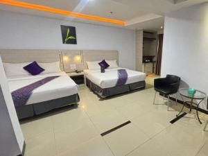 a hotel room with two beds and a table at 89 Hotel Batam in Nagoya +239 photos