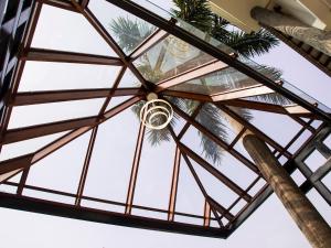 a glass ceiling in a building with palm trees at The Guwahati Address By Centre Point in Guwahati