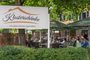 a sign for a restaurant with people sitting at tables at Hotel Kloster Hirsau in Calw