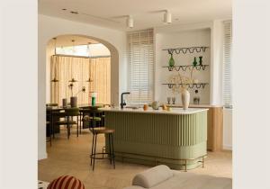 a kitchen with a counter and a table with chairs at The Amber Lotus Hanoi-Elegant Stay with Rooftop Pool & Free Pickup-Near Old Quarter in Hanoi