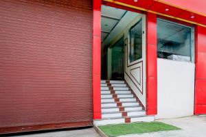 a red building with a red door and stairs at Super Collection O Subedarganj Railway Station Prayagraj in Prayagraj